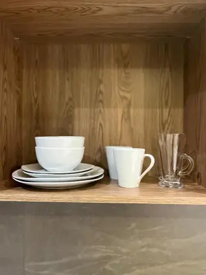 two white cups and plates on a wooden shelf at Chic Deluxe Studio, Menlyn Maine, Smart Access in Pretoria
