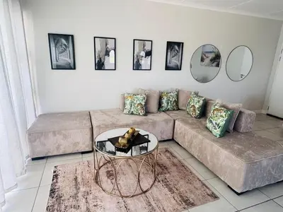 a living room with a couch and a glass table at The Blyde Pretoria in Pretoria