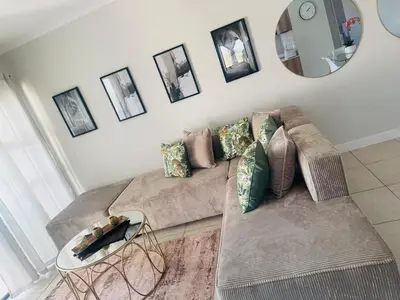 a living room with a couch and a mirror at The Blyde Pretoria in Pretoria