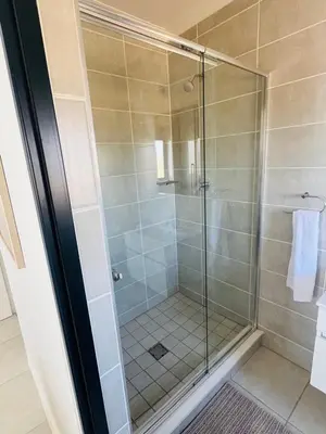 a shower with a glass door in a bathroom at The Blyde Pretoria in Pretoria