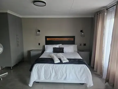a bedroom with a bed with two towels on it at Vation Nation Guest House in Mokopane