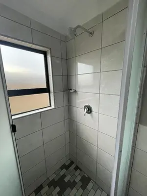 a bathroom with a shower with a window at Vation Nation Guest House in Mokopane