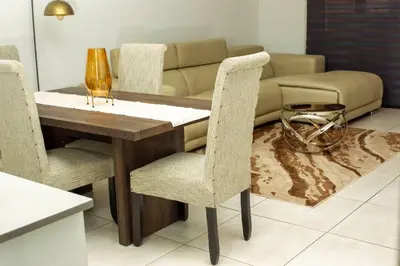 a dining room table with two chairs and a couch at Aurora Executive Stay In Waterfall City in Midrand