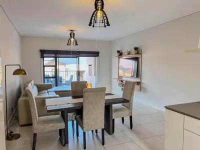 a kitchen and dining room with a table and chairs at Aurora Executive Stay In Waterfall City in Midrand
