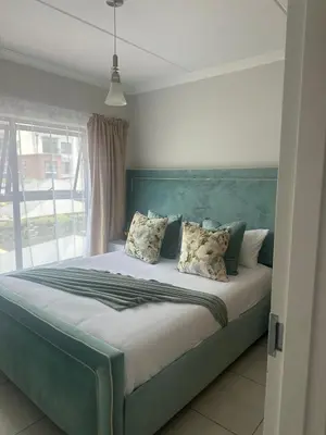 a bed with a blue headboard in a bedroom at The Blyde Crystal Logon in Pretoria
