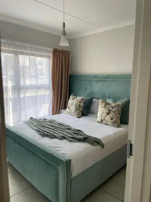 a bed with a blue headboard in a bedroom at The Blyde Crystal Logon in Pretoria