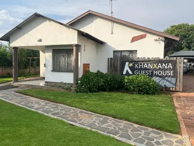 a white house with a sign in front of it at Khanxana guesthouse in Olifantsfontein