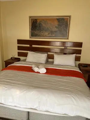 a bedroom with a large bed with two towels on it at Khanxana guesthouse in Olifantsfontein