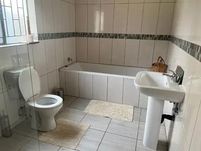 a bathroom with a toilet and a sink and a tub at Khanxana guesthouse in Olifantsfontein