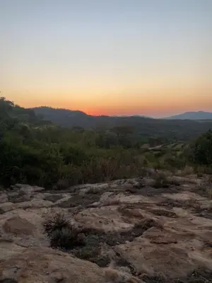 a sunset on top of a mountain with trees at Ses'fikile