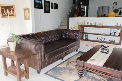 a brown leather couch in a living room with a table at Ses'fikile