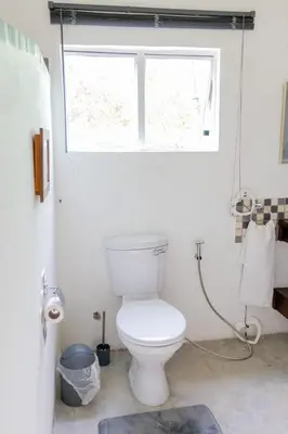 a bathroom with a white toilet and a window at Ses'fikile