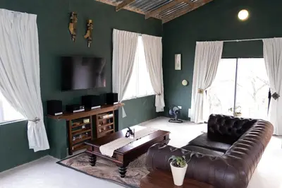 a living room with a leather couch and a tv at Ses'fikile