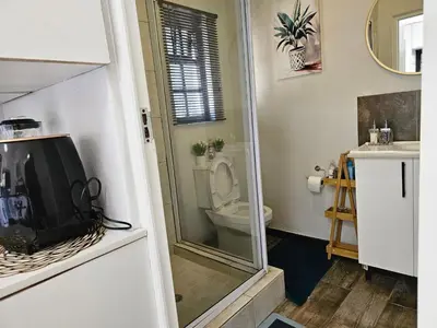 a bathroom with a toilet and a tv in a room at The Little Haven in Midrand