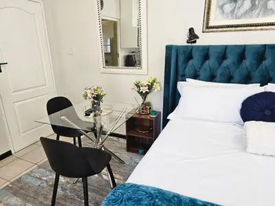 a bedroom with a bed and a glass table at The Little Haven in Midrand