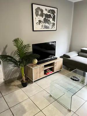 a living room with a tv on a wooden entertainment center at Wotela in Chartwell