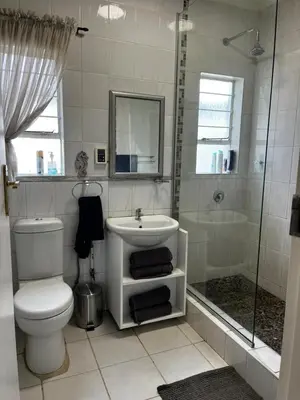 a bathroom with a toilet and a sink and a shower at Cactus Road Guest House in Midrand