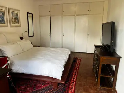a bedroom with a bed and a flat screen tv at Cactus Road Guest House in Midrand