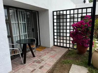 a patio with a table and a vase of flowers at Cactus Road Guest House in Midrand