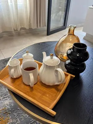 a tray with two cups of tea and a vase at Real Kee in Midrand