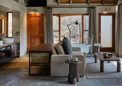 a living room with a couch and a bath tub at Toro River by Newmark in Makalali Game Reserve