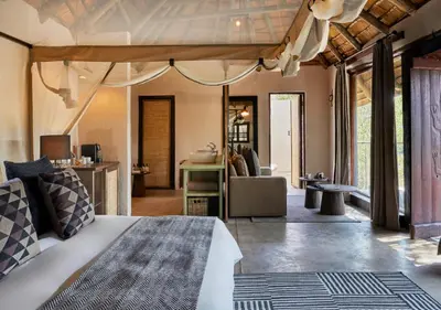 a bedroom with a bed and a living room at Toro River by Newmark in Makalali Game Reserve