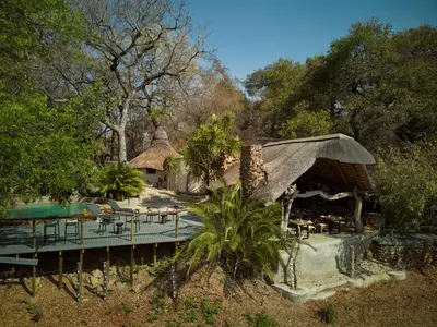 a resort with a pool and tables and chairs at Toro River by Newmark in Makalali Game Reserve