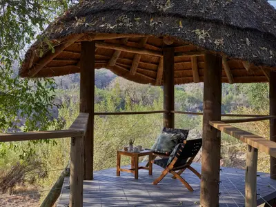 a wooden gazebo with a chair and a table at Toro River by Newmark in Makalali Game Reserve