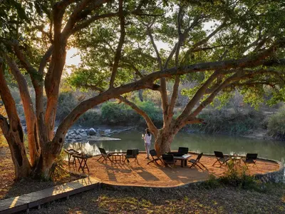 a person standing on a boardwalk next to a river at Toro River by Newmark in Makalali Game Reserve