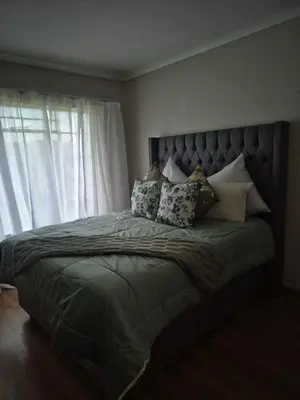 a bedroom with a large bed with pillows on it at Elysium Falls House in Roodeplaat