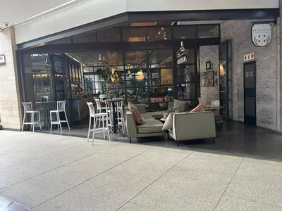 a restaurant with chairs and tables in a building at Delarose business leisure Studio in Pretoria