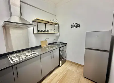 a kitchen with a stove and a sink and a refrigerator at Austin Manor in Midrand