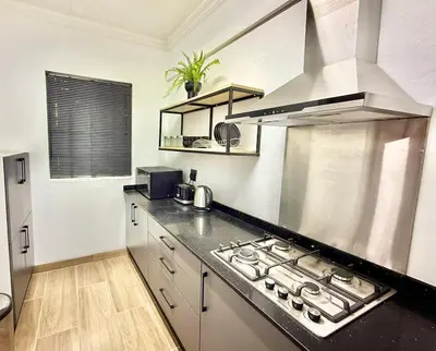 a kitchen with a stove top oven in a kitchen at Austin Manor in Midrand