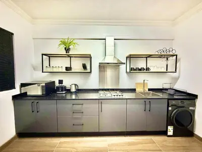 a kitchen with a sink and a stove top oven at Austin Manor in Midrand