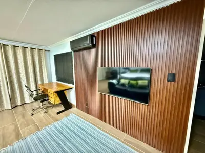 a room with a desk and a painting on a wall at Austin Manor in Midrand