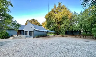 a building with a patio and an umbrella at Austin Manor in Midrand