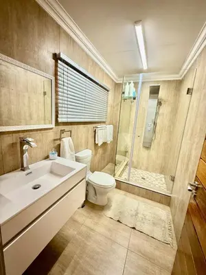 a bathroom with a toilet and a shower and a sink at Austin Manor in Midrand