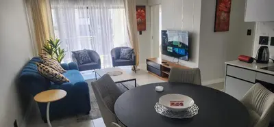 a living room with a blue couch and a table at The Blyde Crystal Lagoon in Pretoria