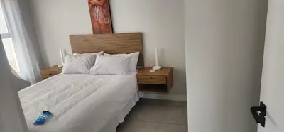 a bedroom with a white bed with a wooden headboard at The Blyde Crystal Lagoon in Pretoria