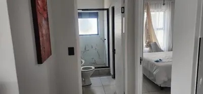 a bathroom with a toilet and a bedroom with a bed at The Blyde Crystal Lagoon in Pretoria