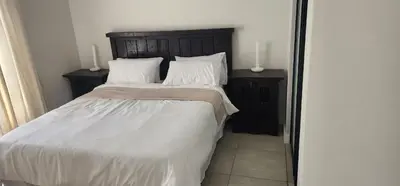 a bedroom with a large bed with white sheets and pillows at The Blyde Crystal Lagoon in Pretoria