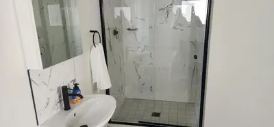 a white bathroom with a shower and a sink at The Blyde Crystal Lagoon in Pretoria
