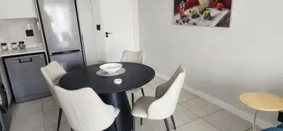 a kitchen with a black table and white chairs at The Blyde Crystal Lagoon in Pretoria