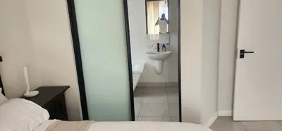 a bedroom with a bathroom with a sink and a mirror at The Blyde Crystal Lagoon in Pretoria