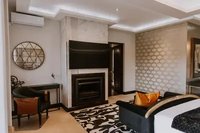a hotel room with a bed and a fireplace at The Villa Palms in Pretoria