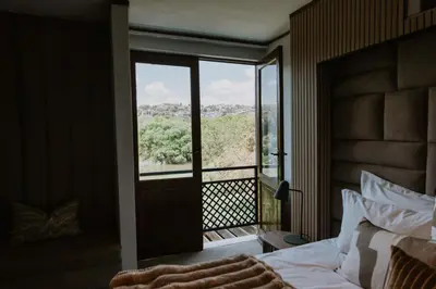 a bedroom with a bed and a balcony with a view at The Villa Palms in Pretoria