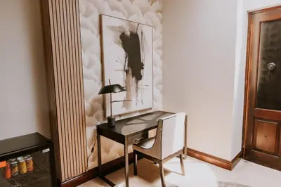 a desk with a lamp and a picture on a wall at The Villa Palms in Pretoria