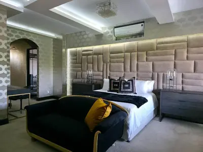 a bedroom with a large bed and a couch at The Villa Palms in Pretoria