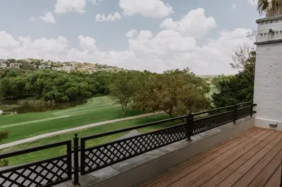 a balcony with a view of a golf course at The Villa Palms in Pretoria