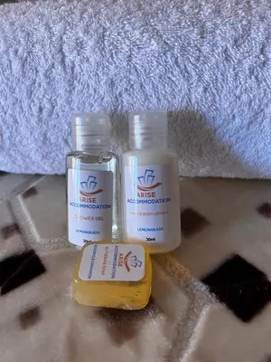 two bottles of moisturizers sitting on a bathroom floor at Royal Apartments in Burgersfort